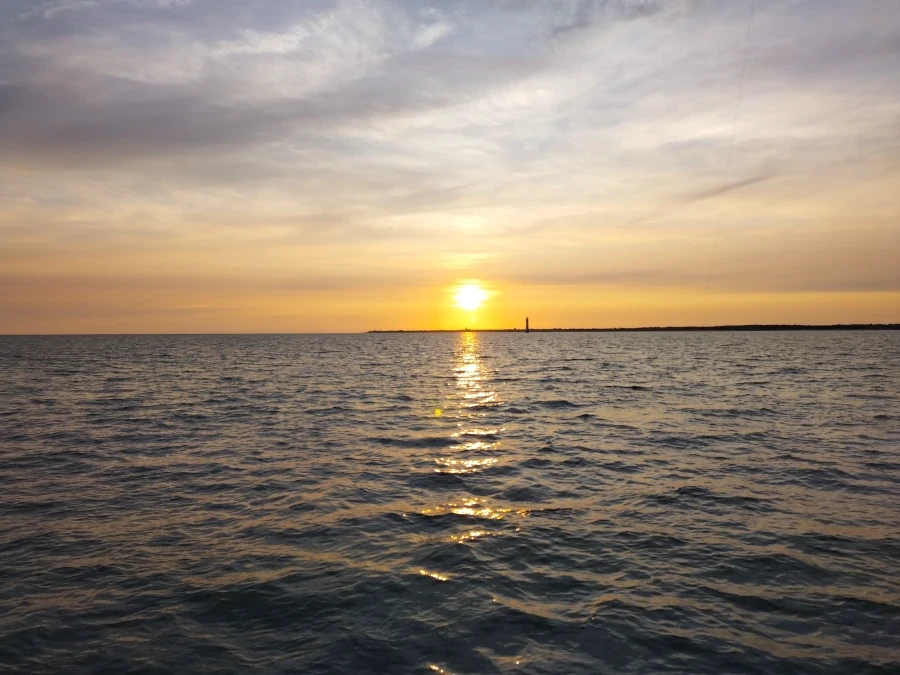coucher de soleil au dessus de l'ile de Ré, vu de la mer ciel orange et gris 